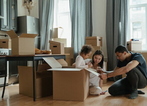 Family packing household belongings into boxes for international relocation