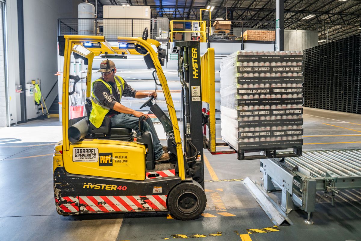 Forklift operator handling pallets in a professional warehouse